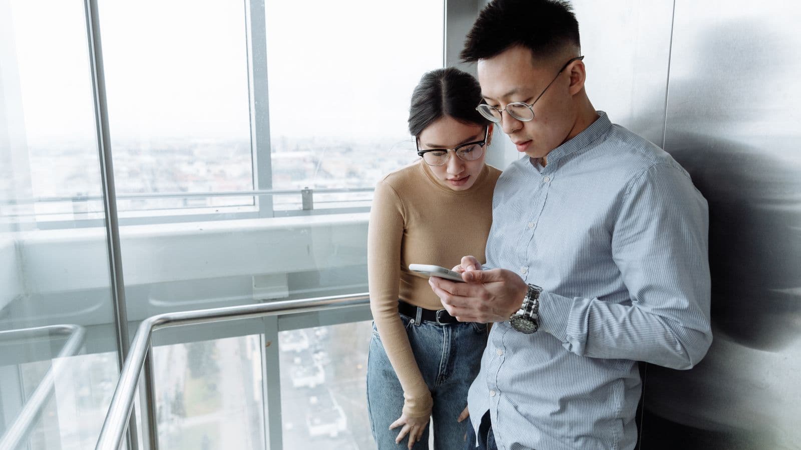 A hotel manager and a creator looking at a phone screen in a hotel lobby
