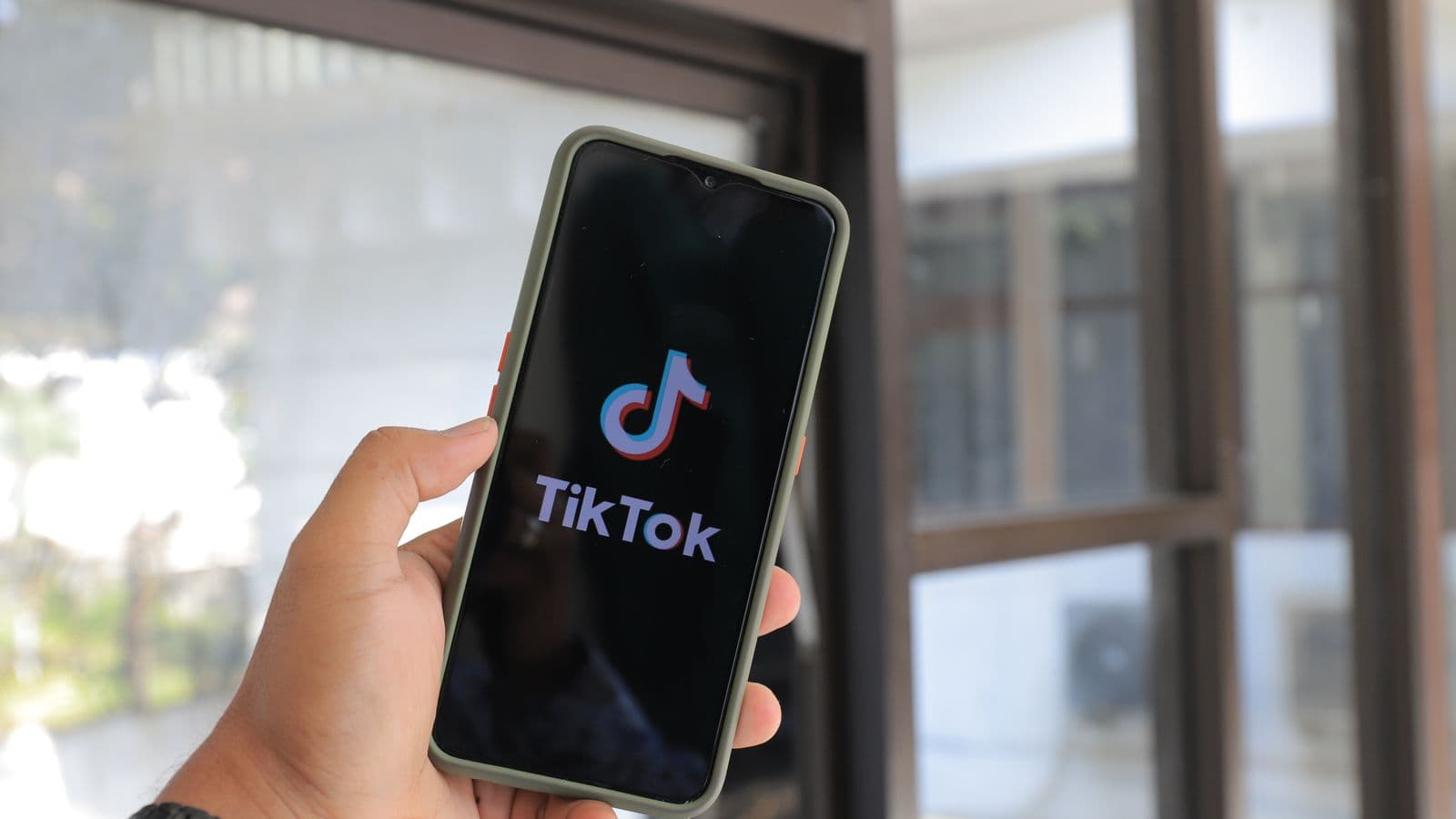 Χέρι που κρατά smartphone με ανοιχτή την εφαρμογή TikTok